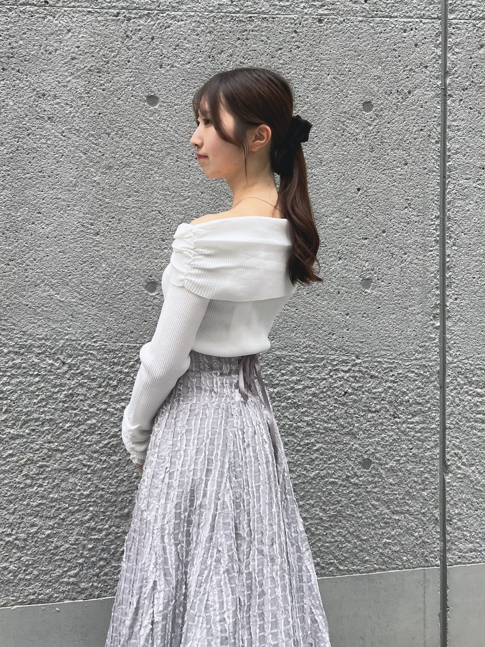 グレー系のスカート、ホワイト系のニット/セーター、ベージュ系のショルダーバッグを着用したレディースの秋コーディネートの7枚目の写真