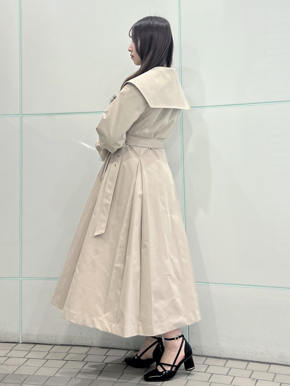 ベージュ系のトレンチコート、ブラック系のサンダルを着用したレディースの冬コーディネートの4枚目の写真