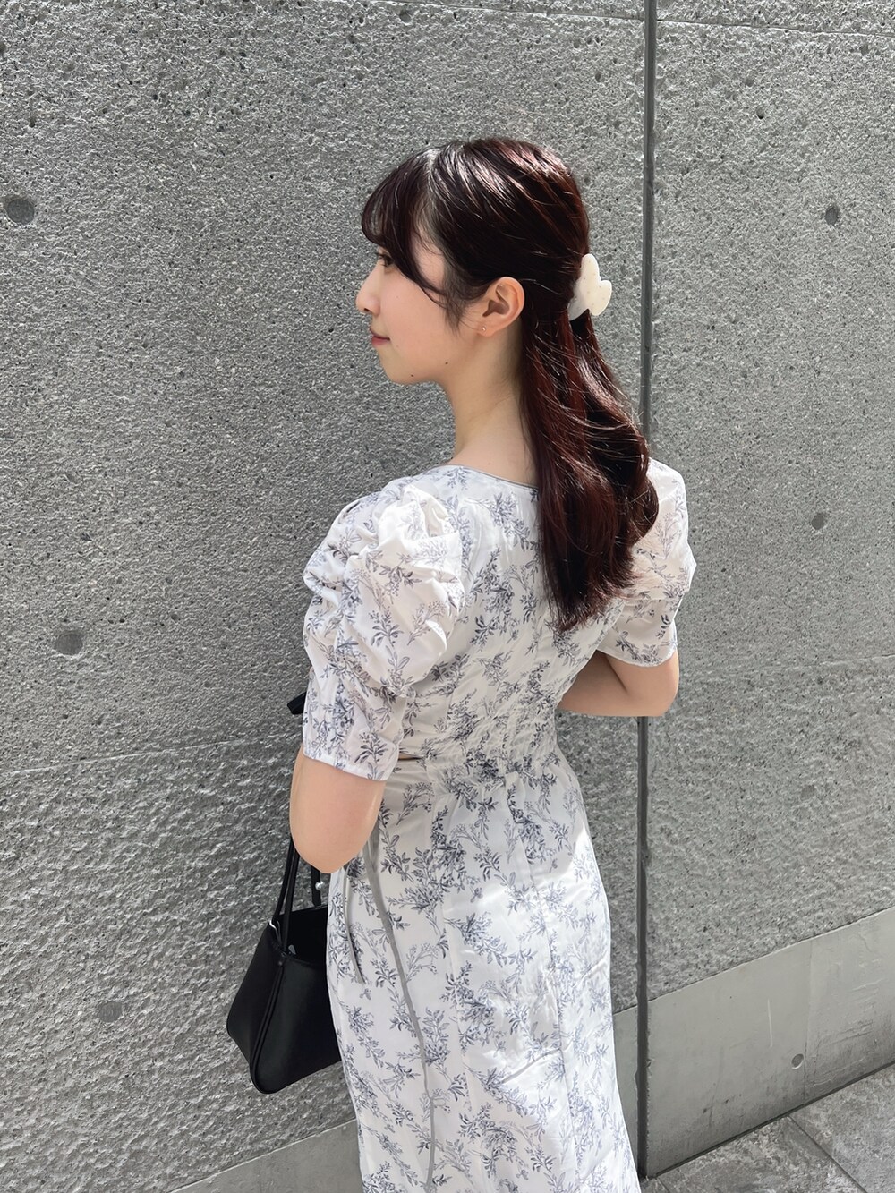 ホワイト系のワンピース、ブラック系のハンドバッグ、ホワイト系のサンダルを着用したレディースの夏コーディネートの7枚目の写真