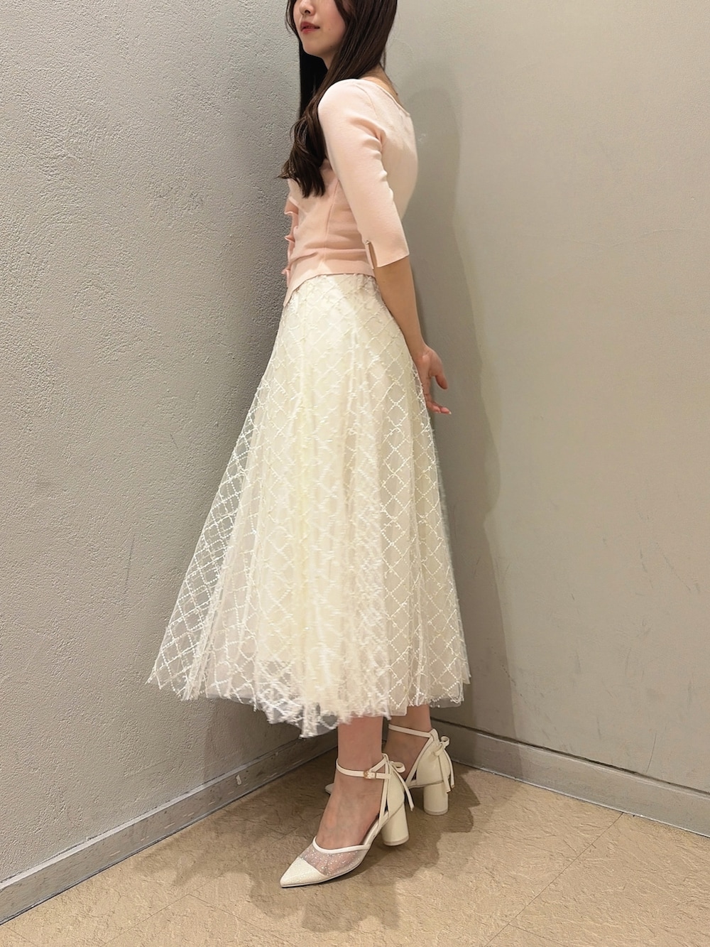 ホワイト系のパンプス、ホワイト系のハンドバッグ、ホワイト系のスカートを着用したレディースの夏コーディネートの3枚目の写真