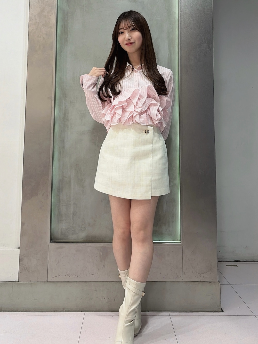 ピンク系のシャツ/ブラウス、ホワイト系のスカート、ホワイト系のブーツを着用したレディースの春コーディネートの2枚目の写真