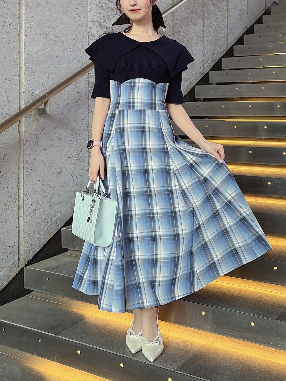 ブルー系のワンピース、ブルー系のハンドバッグ、ホワイト系のパンプスを着用したレディースの春コーディネートの7枚目の写真