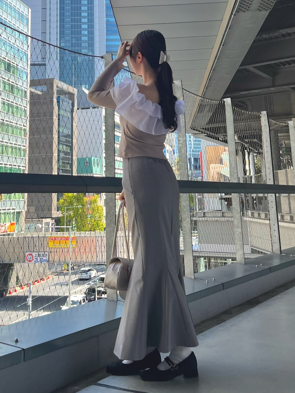 ブルー系のスカート、ピンク系のTシャツ/カットソー、ベージュ系のハンドバッグを着用したレディースの春コーディネートの3枚目の写真