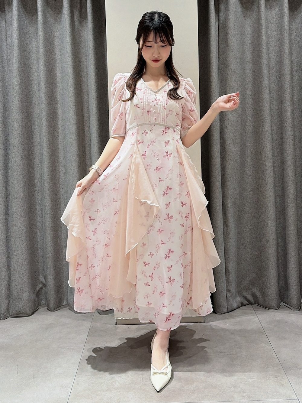 ピンク系のワンピース、ホワイト系のパンプスを着用したレディースの春コーディネートの2枚目の写真
