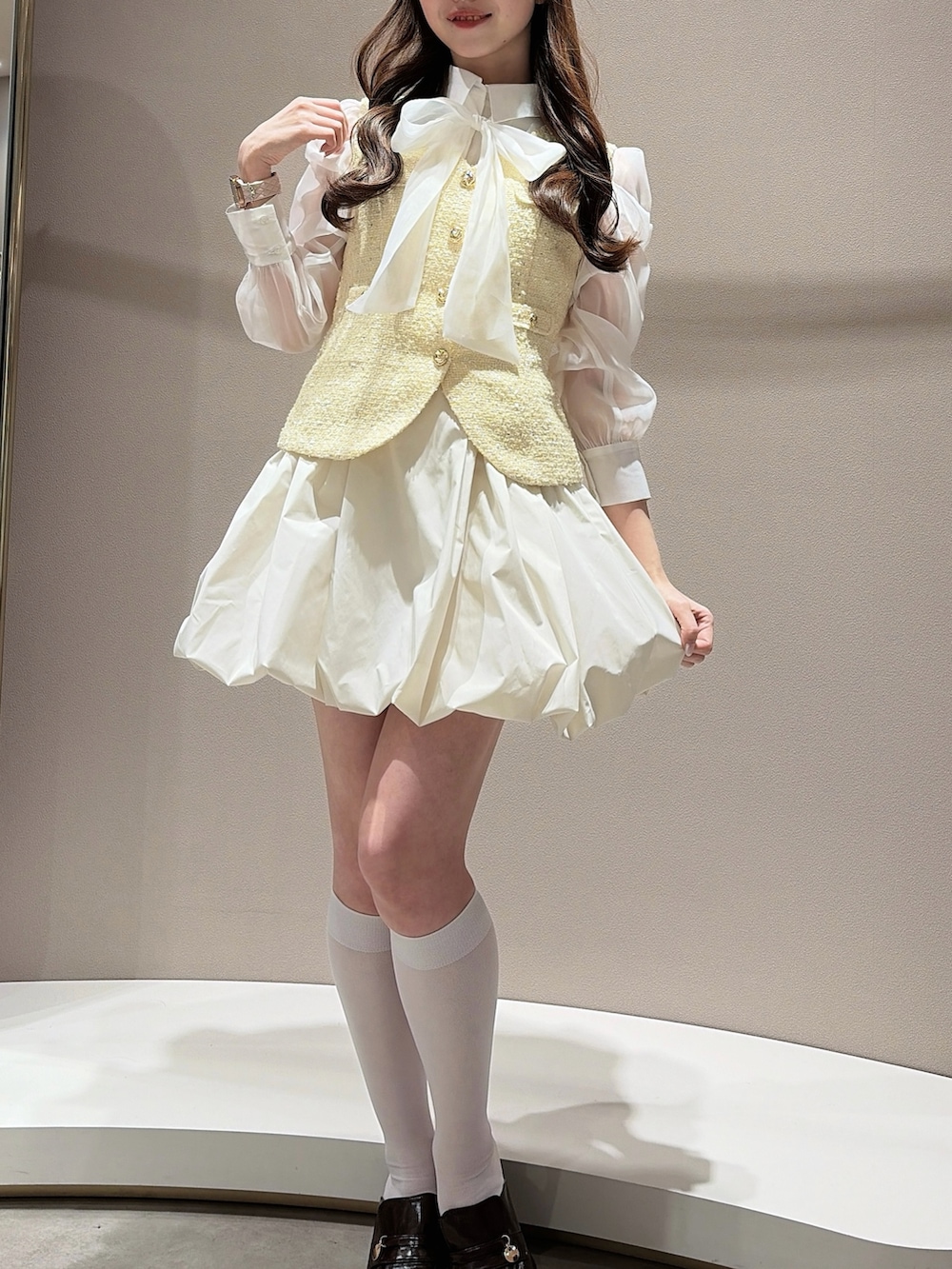 イエロー系のワンピース、その他のシャツ/ブラウス、ブラウン系のパンプスを着用したレディースの春コーディネートの2枚目の写真