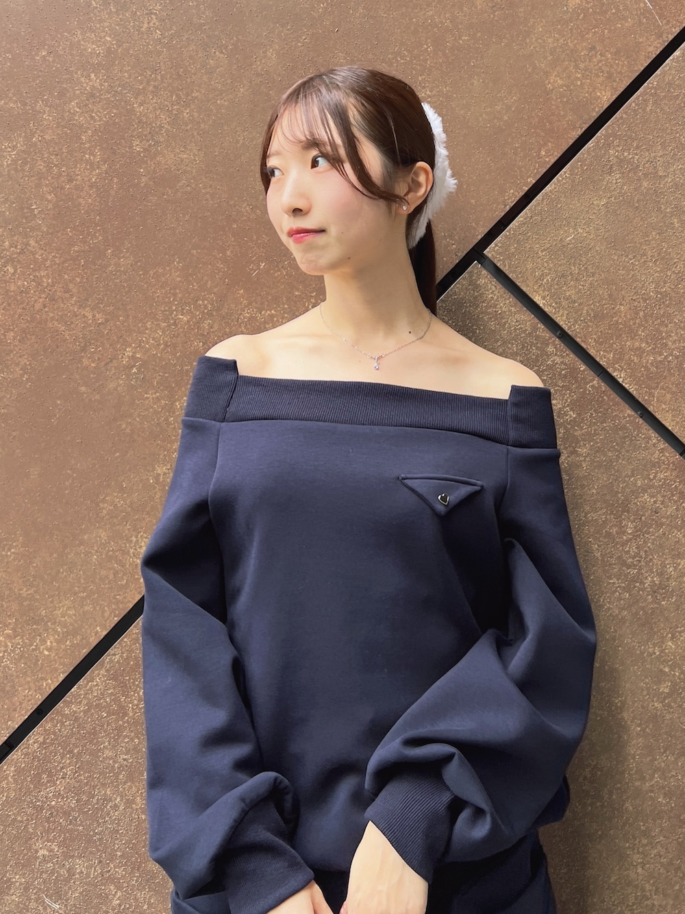 ブルー系のスウェット、ブルー系のスカート、ブラック系のハンドバッグを着用したレディースの秋コーディネートの5枚目の写真