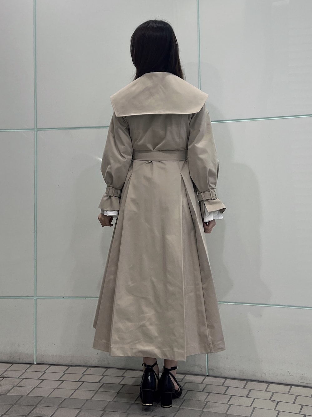 ベージュ系のトレンチコート、ブラック系のサンダルを着用したレディースの冬コーディネートの5枚目の写真