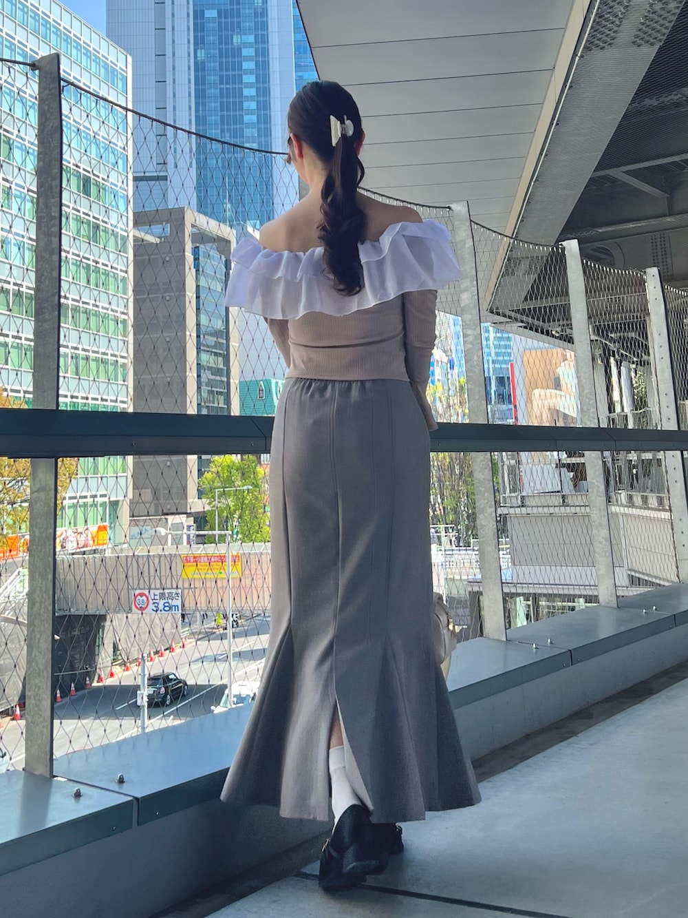 ブルー系のスカート、ピンク系のTシャツ/カットソー、ベージュ系のハンドバッグを着用したレディースの春コーディネートの4枚目の写真