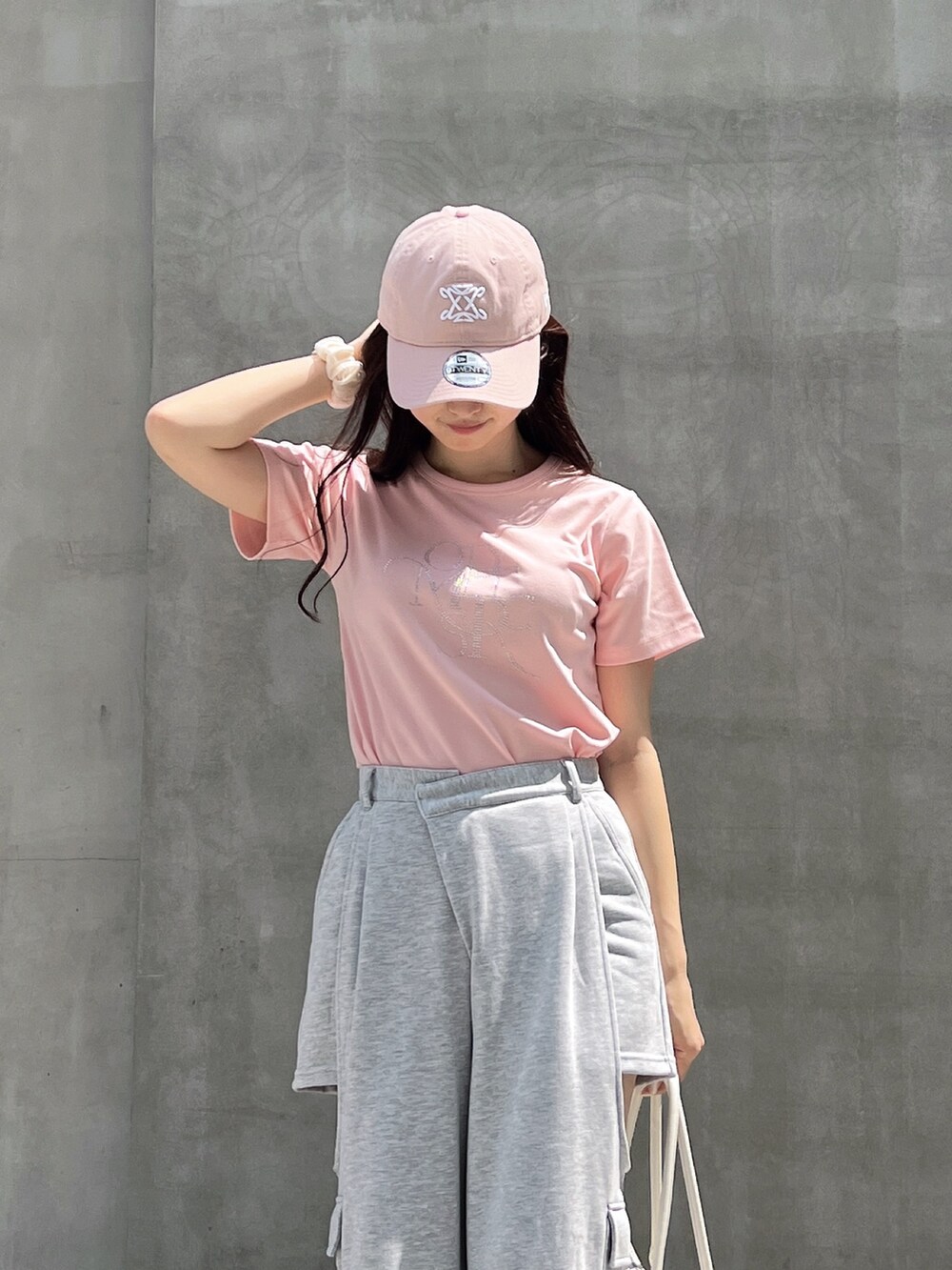 グレー系のカーゴパンツ、ピンク系のTシャツ/カットソー、ホワイト系のボストンバッグを着用したレディースの夏コーディネートの8枚目の写真