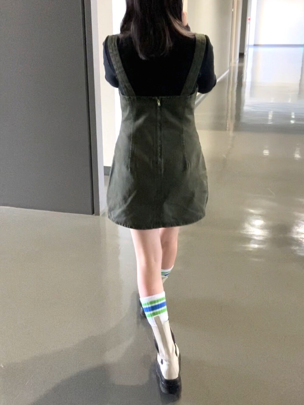 ホワイト系のブーツ、ブラック系のトップス、グリーン系のワンピース/ドレスを着用したレディースの秋コーディネートの2枚目の写真