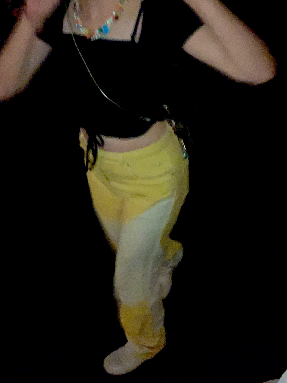 ブラック系のトップス、イエロー系のパンツ、ホワイト系のブーツを着用したレディースの秋コーディネートの3枚目の写真