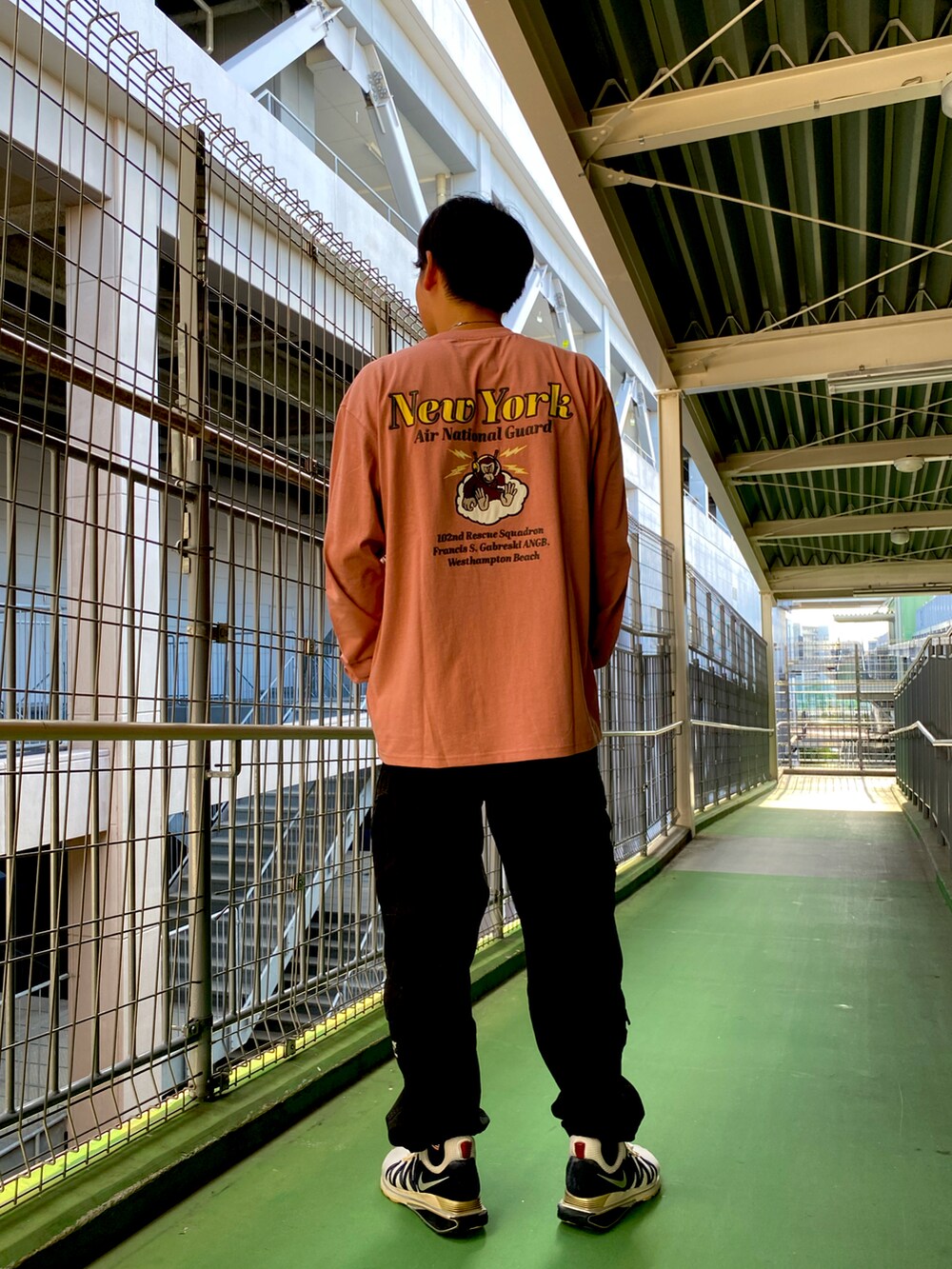 ピンク系のTシャツ/カットソー、ブラック系のカーゴパンツを着用したメンズの秋コーディネートの2枚目の写真