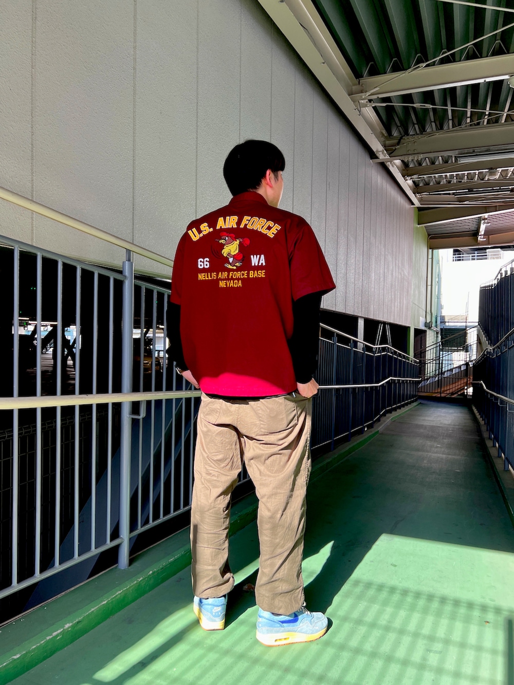 グリーン系のその他パンツ、ブラック系のTシャツ/カットソー、レッド系のトップスを着用したメンズの春コーディネートの2枚目の写真