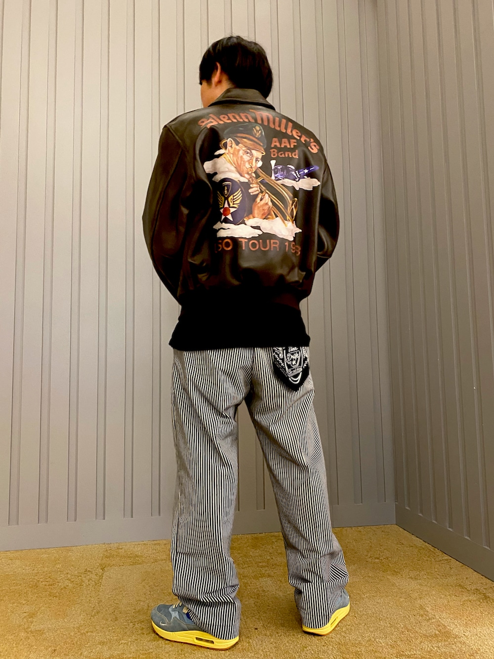 ブラック系のTシャツ/カットソー、その他のチノパンツ、ブラウン系のミリタリージャケットを着用したメンズの夏コーディネートの2枚目の写真