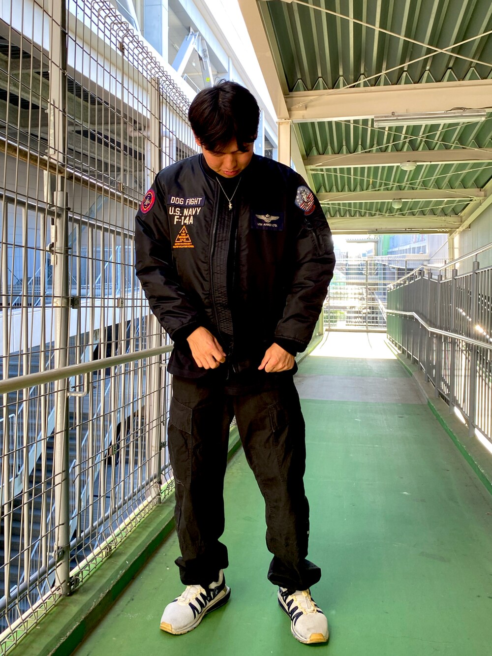 ブラック系のMA-1、ブラック系のカーゴパンツを着用したメンズの秋コーディネートの2枚目の写真