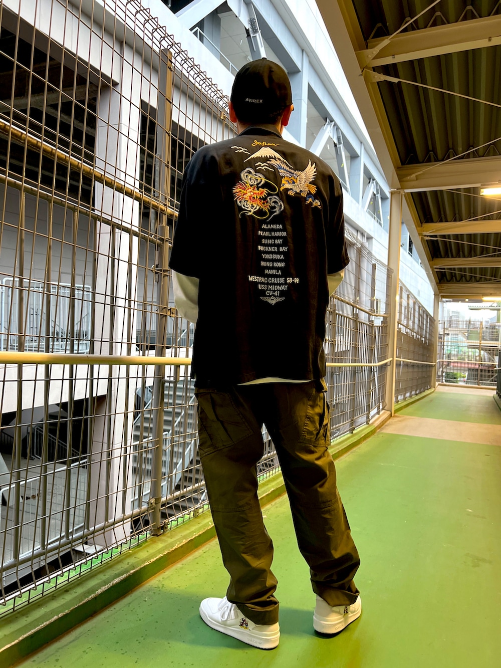 グリーン系のカーゴパンツ、ホワイト系のTシャツ/カットソー、ブラック系のシャツ/ブラウスを着用したメンズの春コーディネートの2枚目の写真