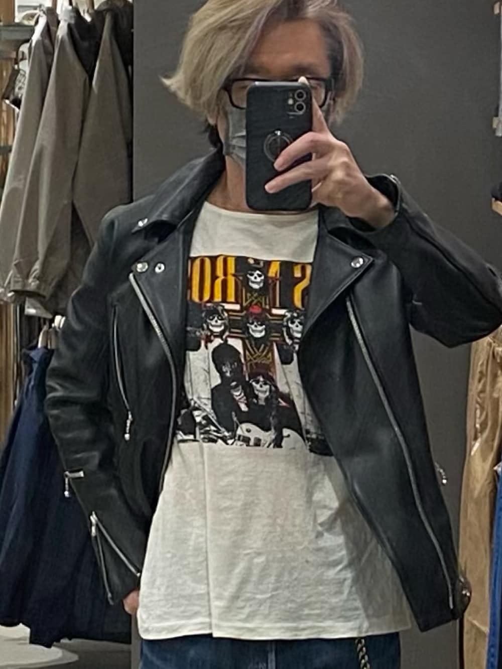 ブラック系のライダースジャケット、ブルー系のデニムパンツ、レッド系のスニーカーを着用したメンズの春コーディネートの2枚目の写真