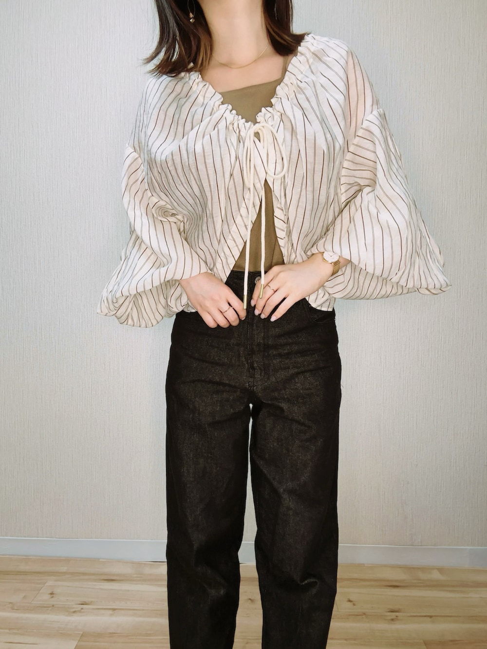 ブラック系のデニムパンツ、ベージュ系のシャツ/ブラウス、ブラウン系のタンクトップを着用したレディースの夏コーディネートの3枚目の写真