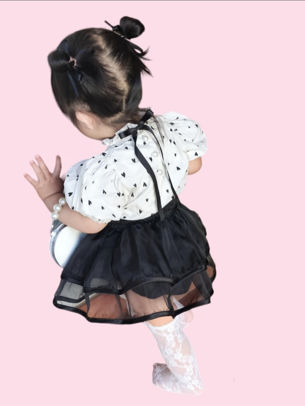 ホワイト系のシャツ/ブラウス、ブラック系のスカート、ホワイト系のハンドバッグを着用したキッズの夏コーディネートの2枚目の写真