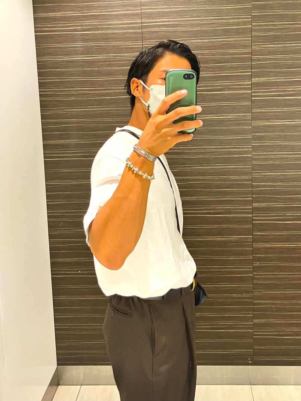 ホワイト系のTシャツ/カットソー、ブラウン系のスラックス、ブラック系のバッグを着用したメンズの夏コーディネートの2枚目の写真