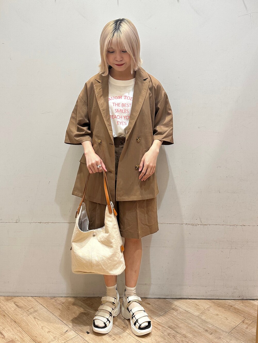 ブラウン系のジャケット/アウター、ホワイト系のTシャツ/カットソー、ホワイト系のハンドバッグを着用したレディースの春コーディネートの2枚目の写真