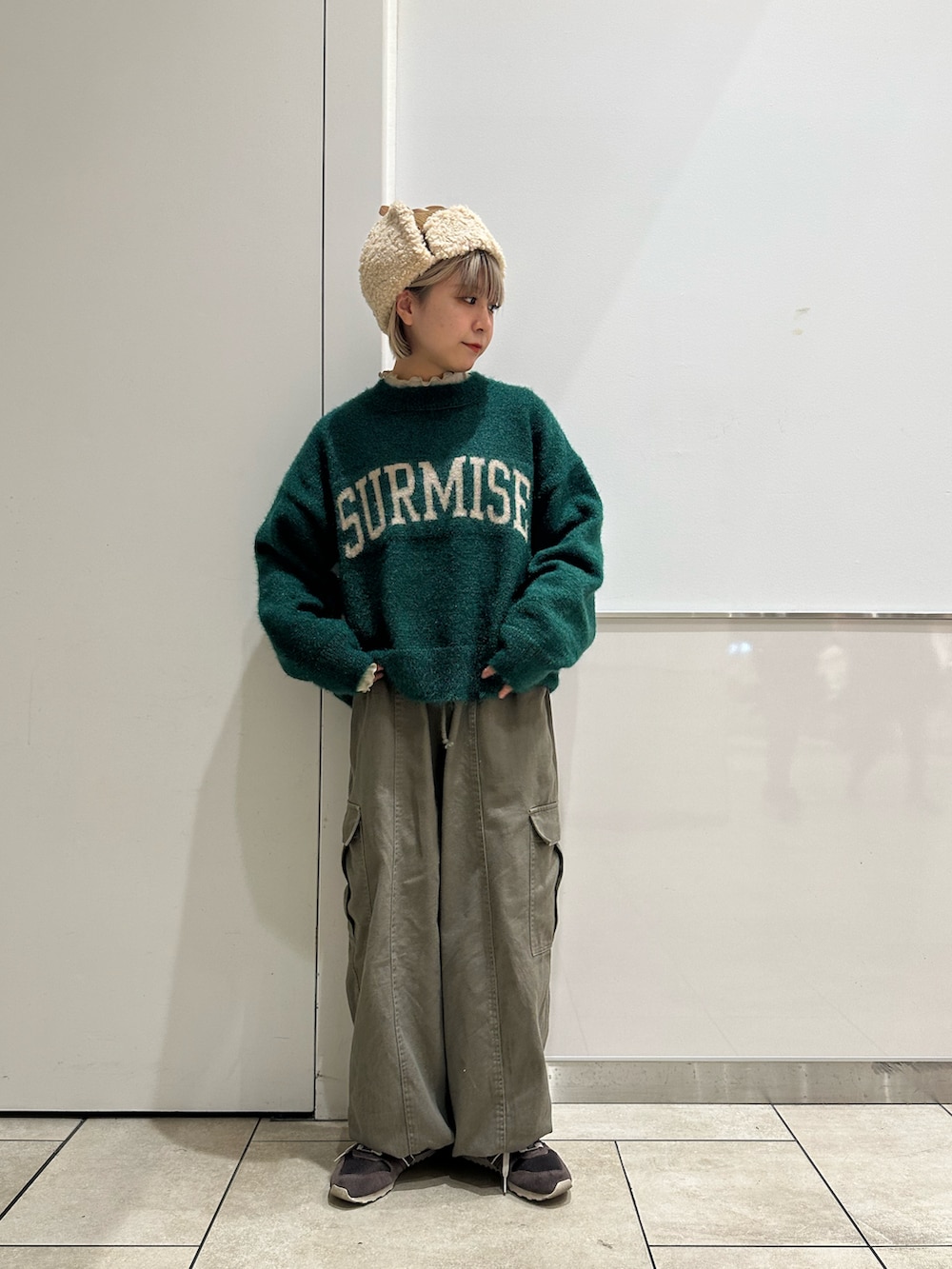 グリーン系のニット/セーター、グリーン系のカーゴパンツ、ベージュ系のTシャツ/カットソーを着用したレディースの冬コーディネートの2枚目の写真