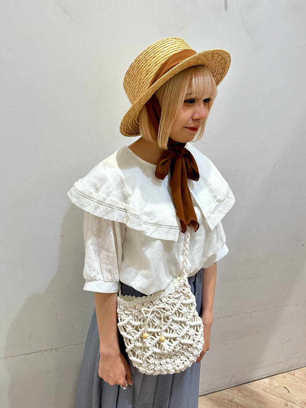 ホワイト系のシャツ/ブラウス、ホワイト系のハンドバッグ、ブルー系のスカートを着用したレディースの春コーディネートの2枚目の写真