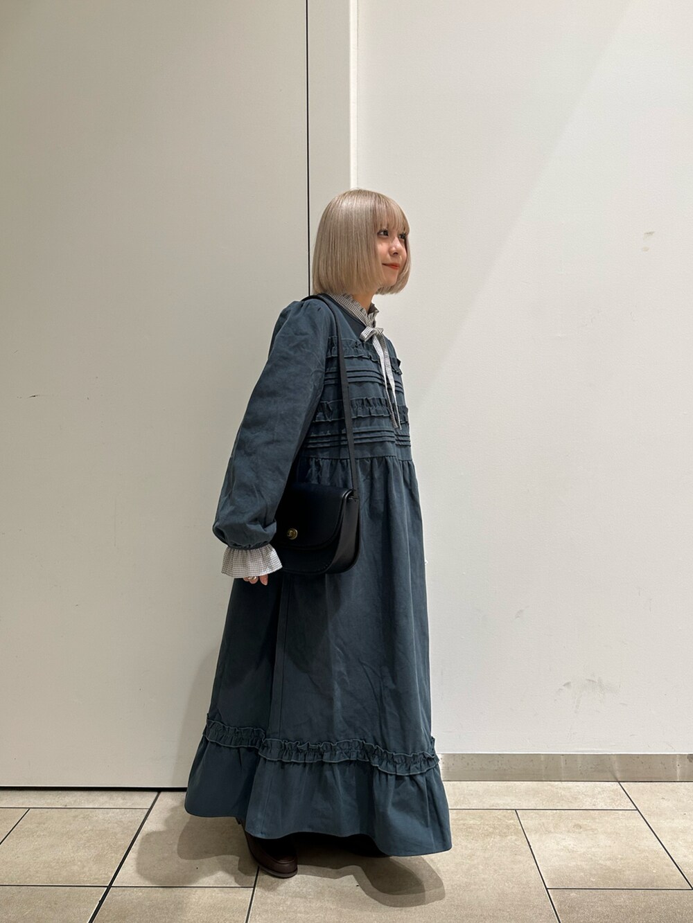 グレー系のシャツ/ブラウス、ブラック系のハンドバッグ、ブラウン系のローファーを着用したレディースの秋コーディネートの2枚目の写真