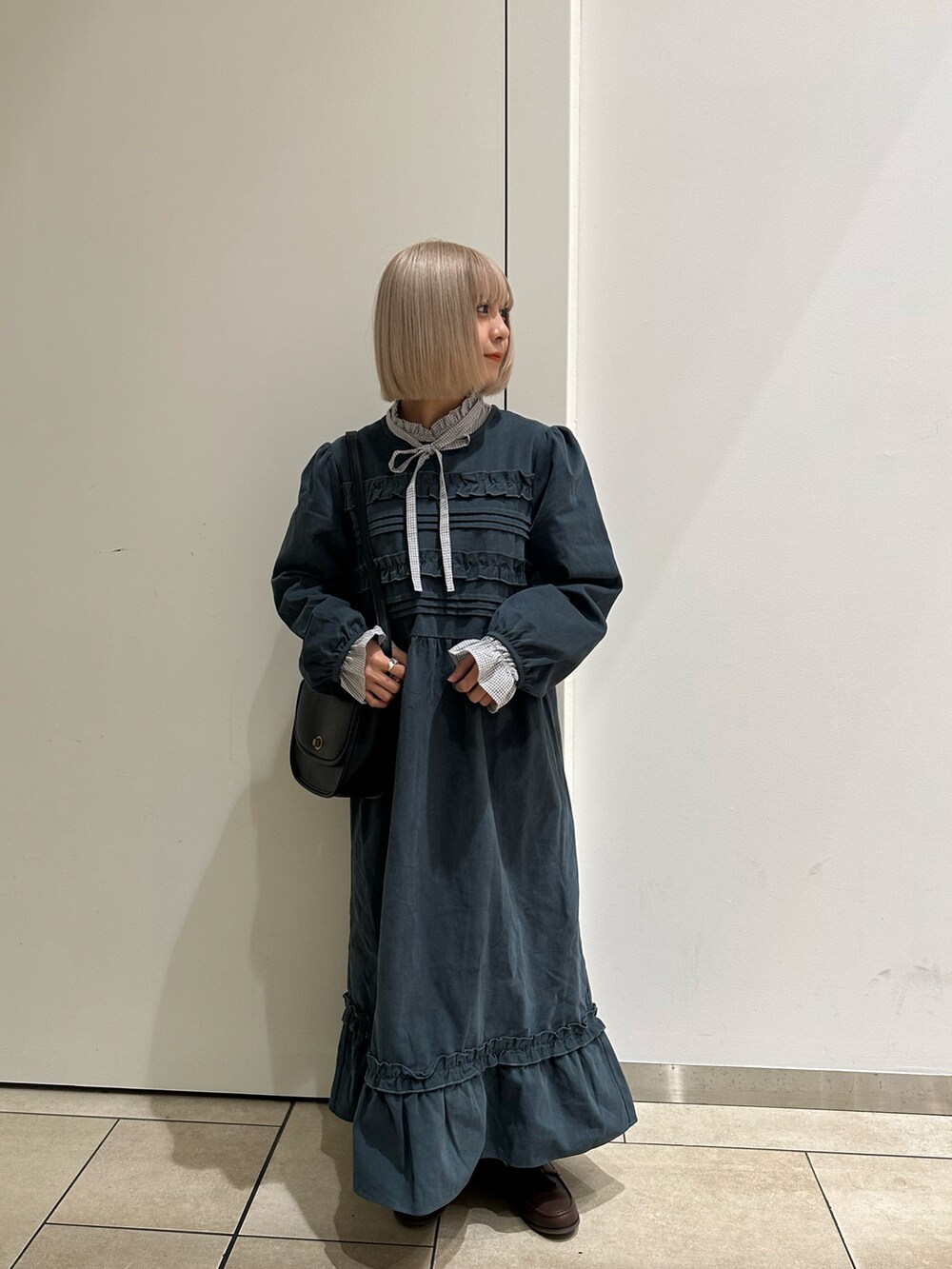 グレー系のシャツ/ブラウス、ブラック系のハンドバッグ、ブラウン系のローファーを着用したレディースの秋コーディネートの3枚目の写真