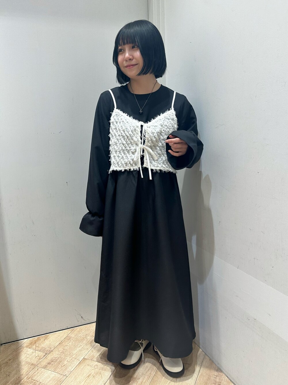 ブラック系のワンピース、ホワイト系のその他シューズを着用したレディースの冬コーディネートの2枚目の写真