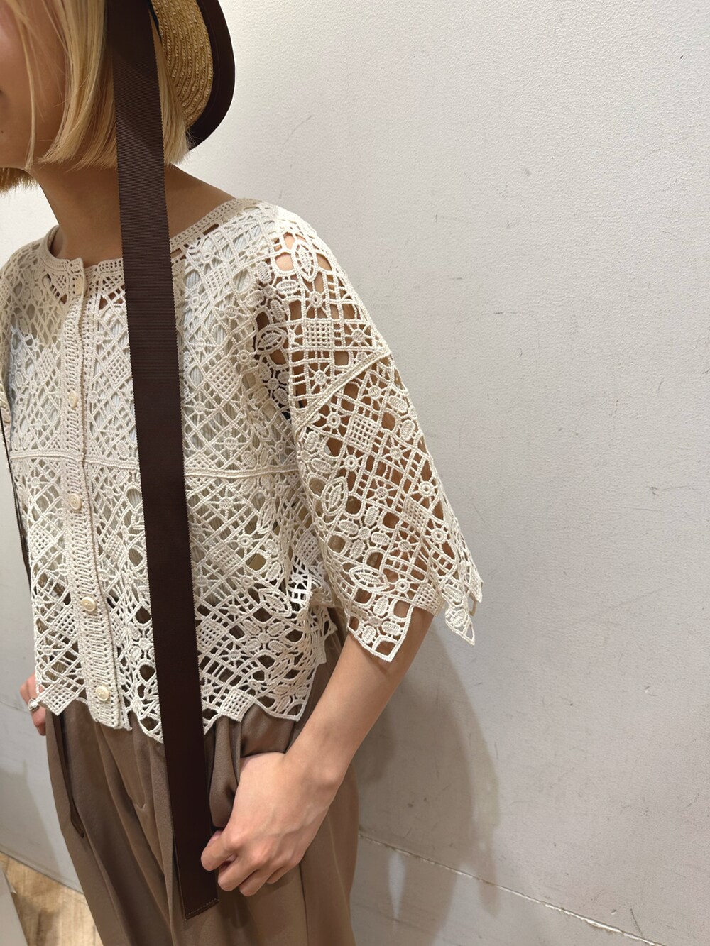 ホワイト系のタンクトップ、ベージュ系のトップス、ブラウン系のその他パンツを着用したレディースの春コーディネートの3枚目の写真