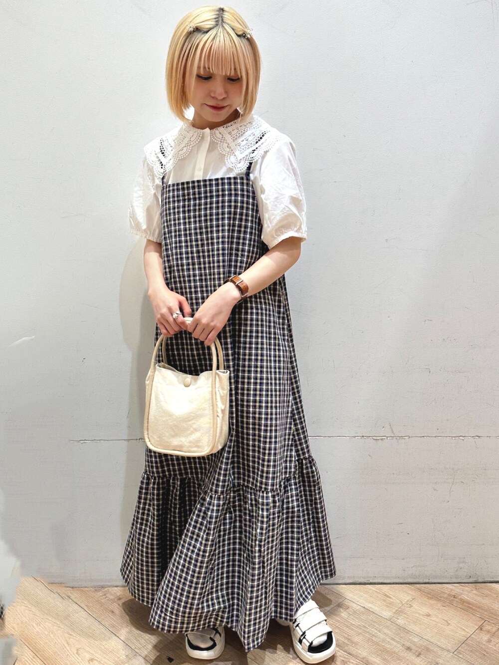 ホワイト系のトップス、ブルー系のワンピース/ドレス、ベージュ系のハンドバッグを着用したレディースの春コーディネートの2枚目の写真