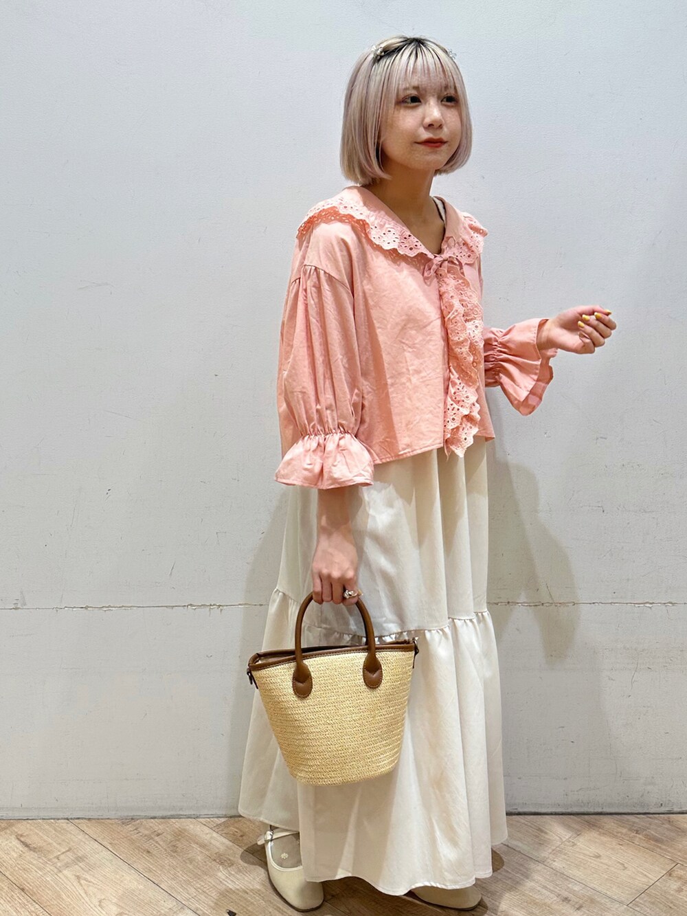 ピンク系のシャツ/ブラウス、ホワイト系のワンピース、イエロー系のハンドバッグを着用したレディースの春コーディネートの4枚目の写真