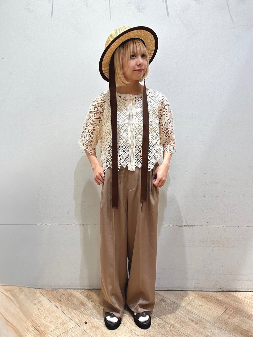 ホワイト系のタンクトップ、ベージュ系のトップス、ブラウン系のその他パンツを着用したレディースの春コーディネートの2枚目の写真