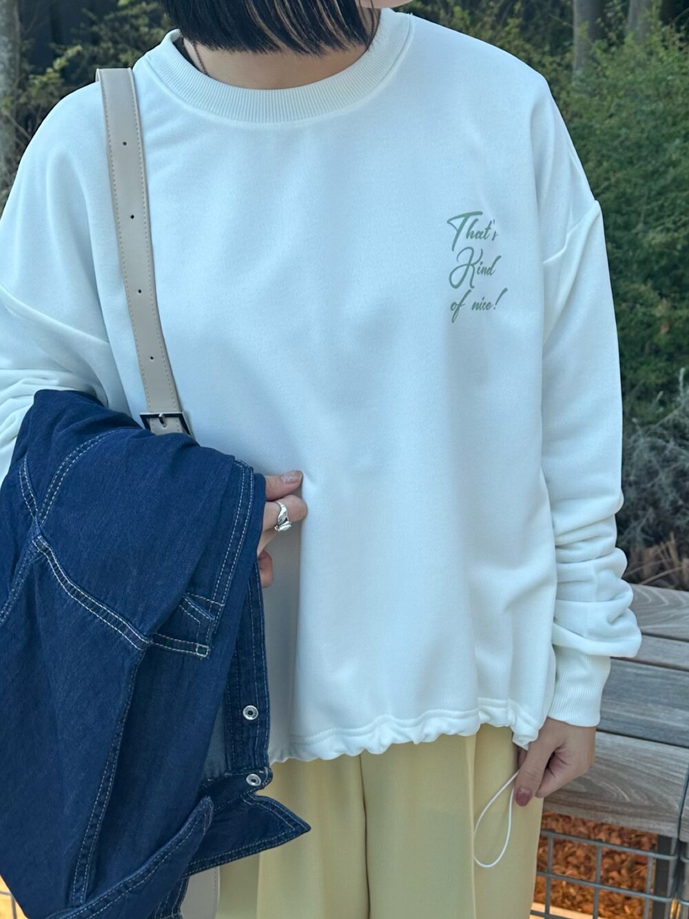 ブルー系のシャツ/ブラウス、イエロー系のその他パンツ、ベージュ系のハンドバッグを着用したレディースの春コーディネートの3枚目の写真