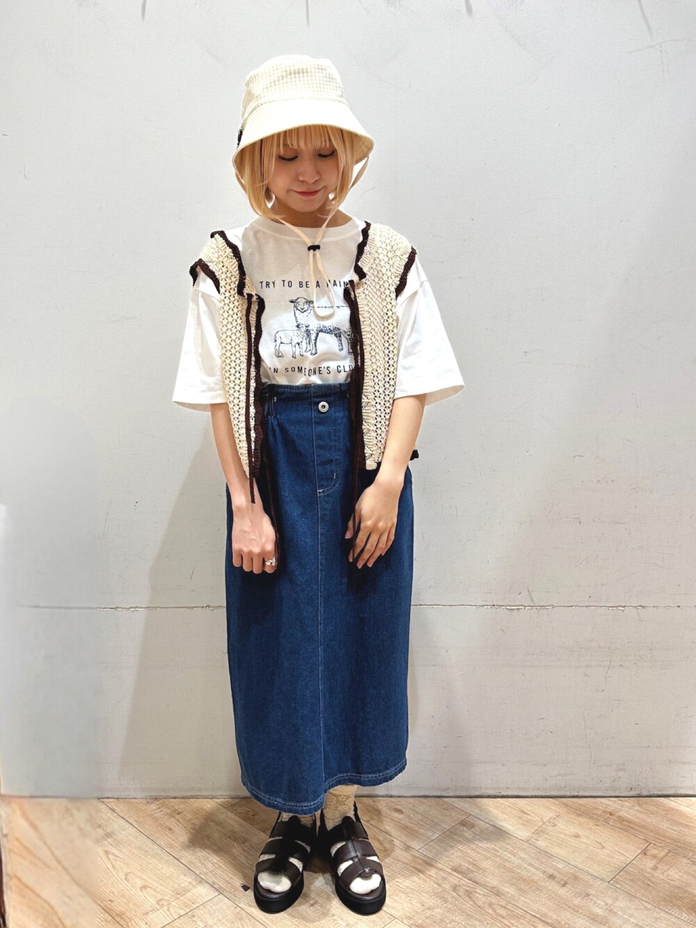 ブラウン系のトップス、ホワイト系のトップス、ブルー系のスカートを着用したレディースの春コーディネートの2枚目の写真