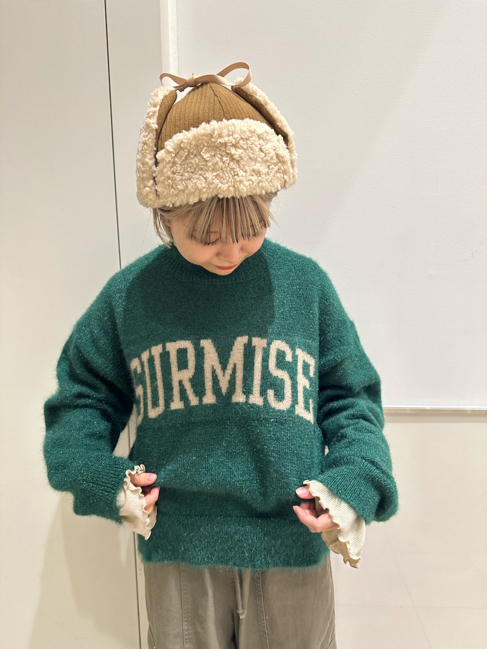 グリーン系のニット/セーター、グリーン系のカーゴパンツ、ベージュ系のTシャツ/カットソーを着用したレディースの冬コーディネートの4枚目の写真