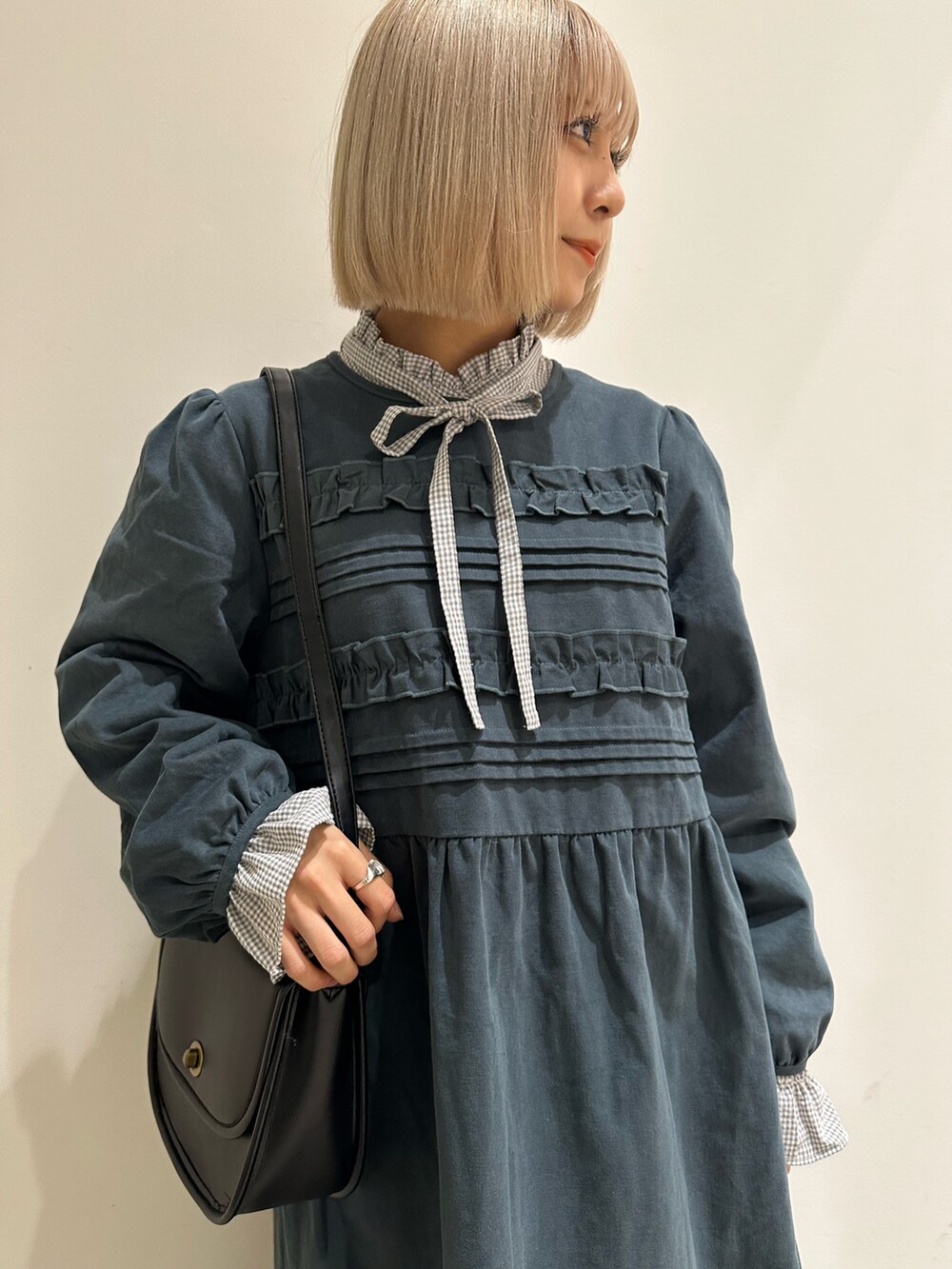 グレー系のシャツ/ブラウス、ブラック系のハンドバッグ、ブラウン系のローファーを着用したレディースの秋コーディネートの4枚目の写真