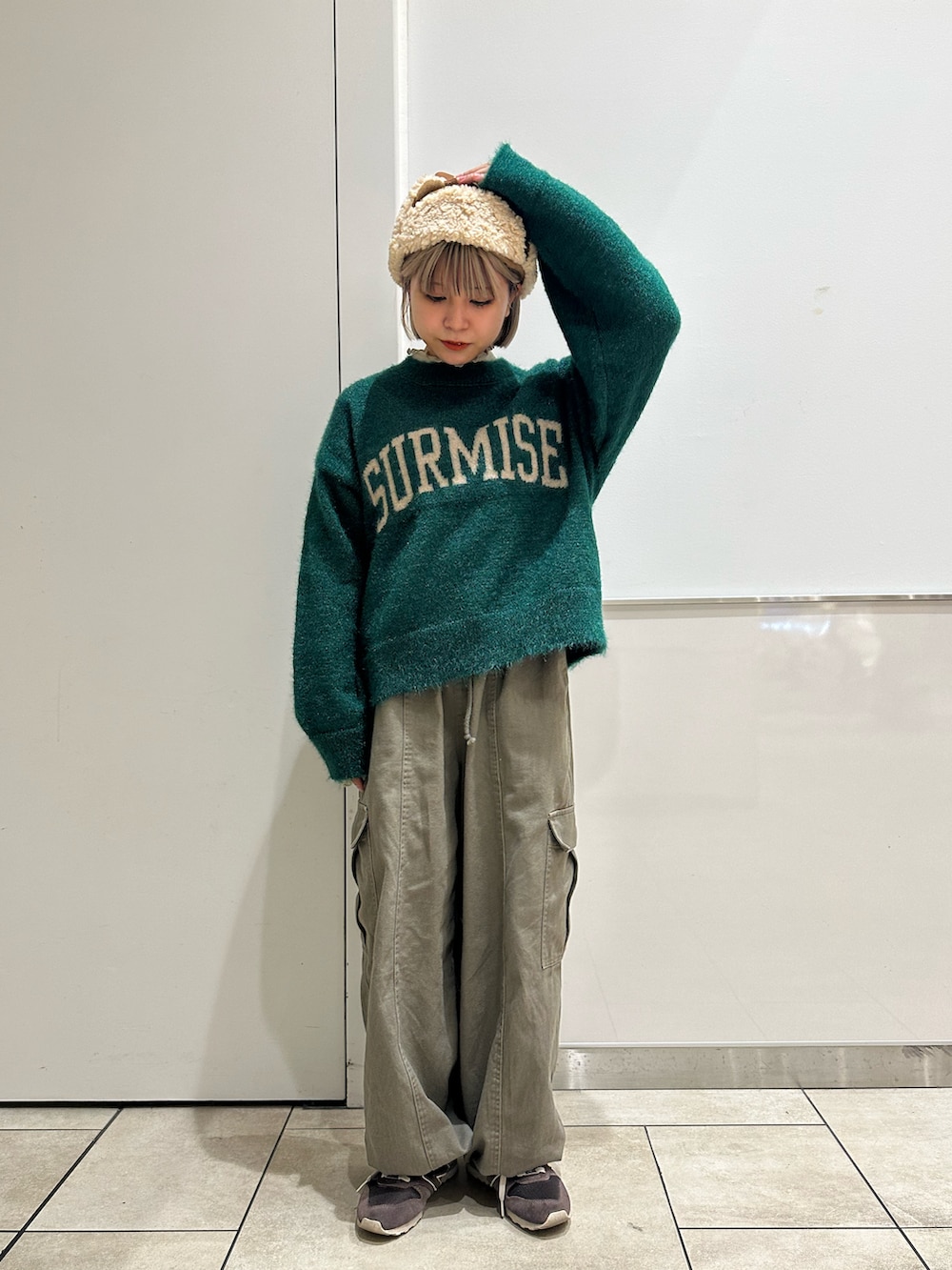 グリーン系のニット/セーター、グリーン系のカーゴパンツ、ベージュ系のTシャツ/カットソーを着用したレディースの冬コーディネートの3枚目の写真