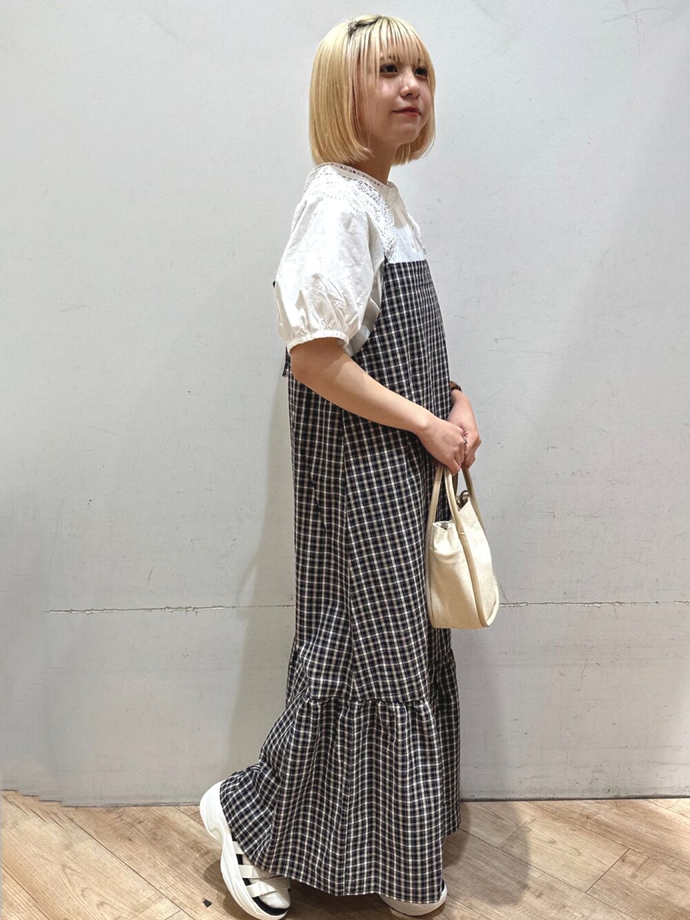 ホワイト系のトップス、ブルー系のワンピース/ドレス、ベージュ系のハンドバッグを着用したレディースの春コーディネートの3枚目の写真