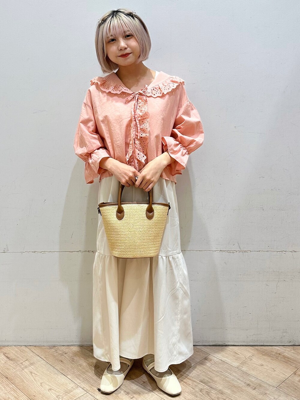 ピンク系のシャツ/ブラウス、ホワイト系のワンピース、イエロー系のハンドバッグを着用したレディースの春コーディネートの2枚目の写真