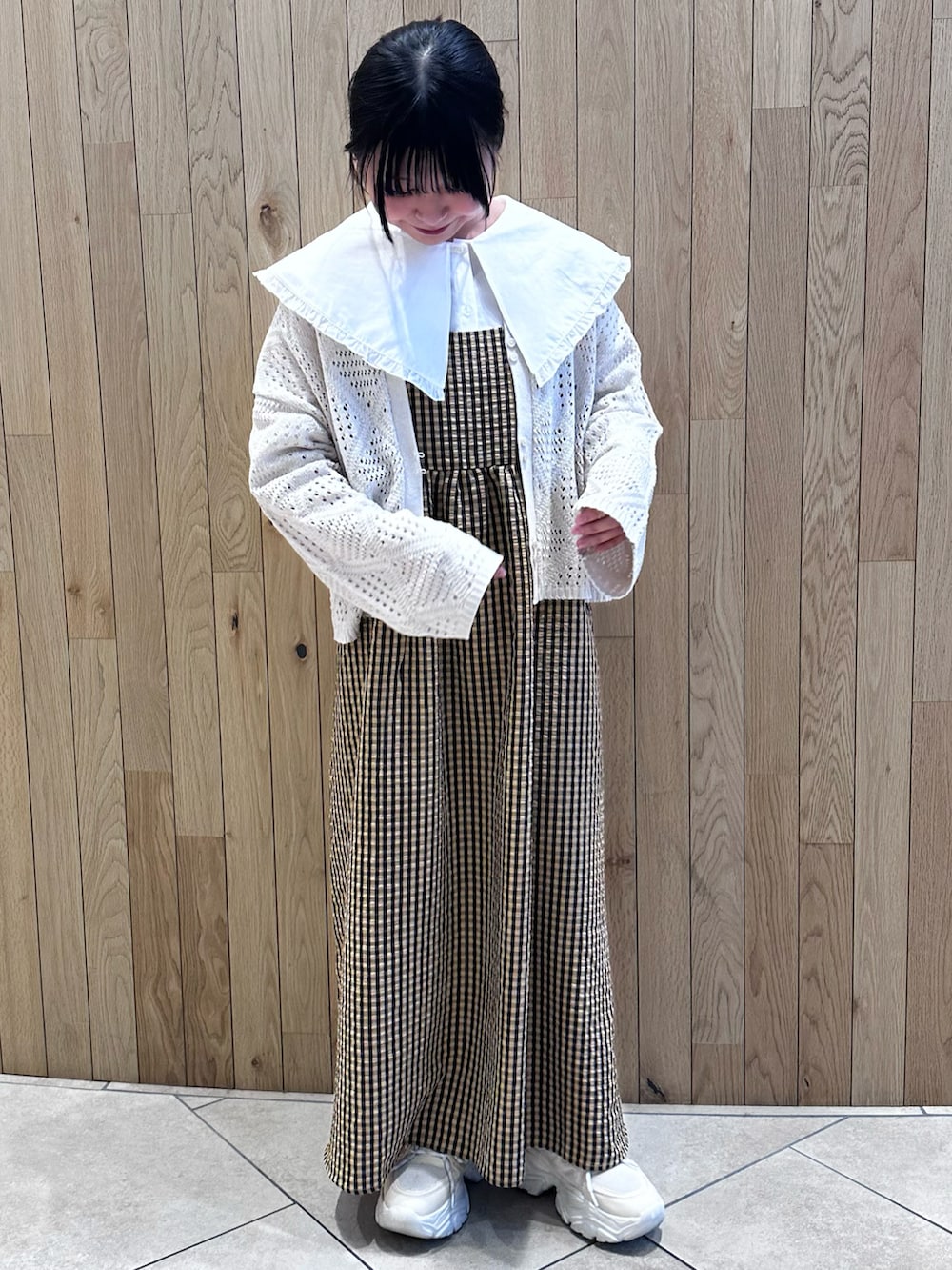 イエロー系のワンピース、ホワイト系のカーディガン/ボレロ、ホワイト系のシャツ/ブラウスを着用したレディースの春コーディネートの2枚目の写真