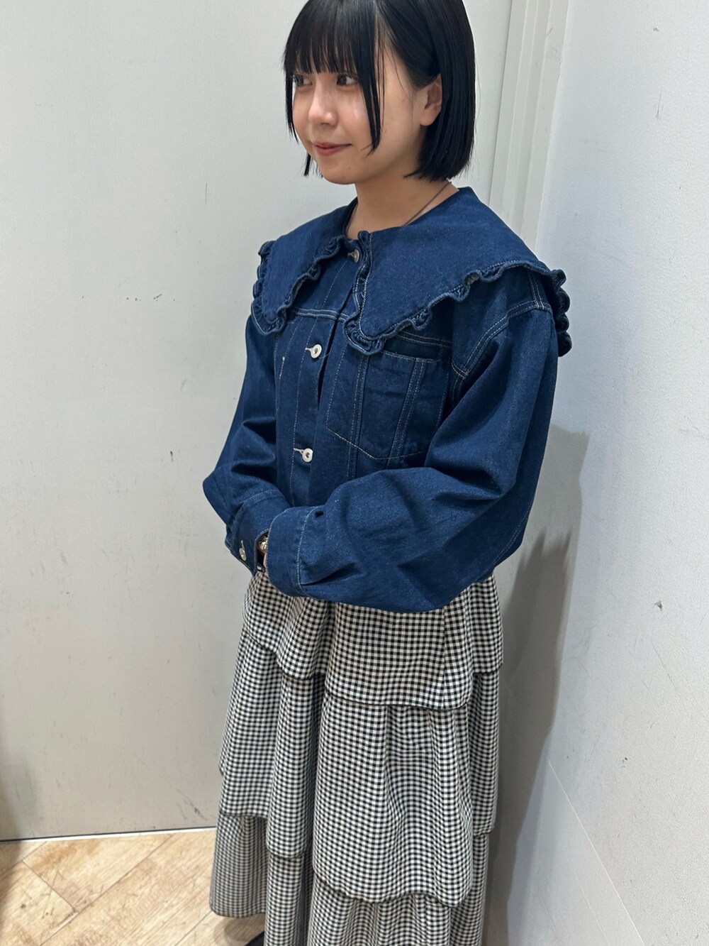 ブルー系のノーカラージャケット、ブラック系のスカート、ブラック系のシューズを着用したレディースの冬コーディネートの2枚目の写真