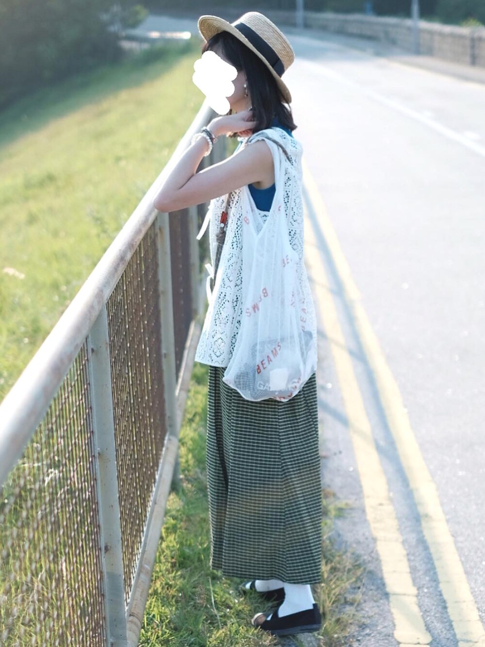 ホワイト系のベスト、ブラック系のスリッポン、ベージュ系のハットを着用したレディースの秋コーディネートの2枚目の写真