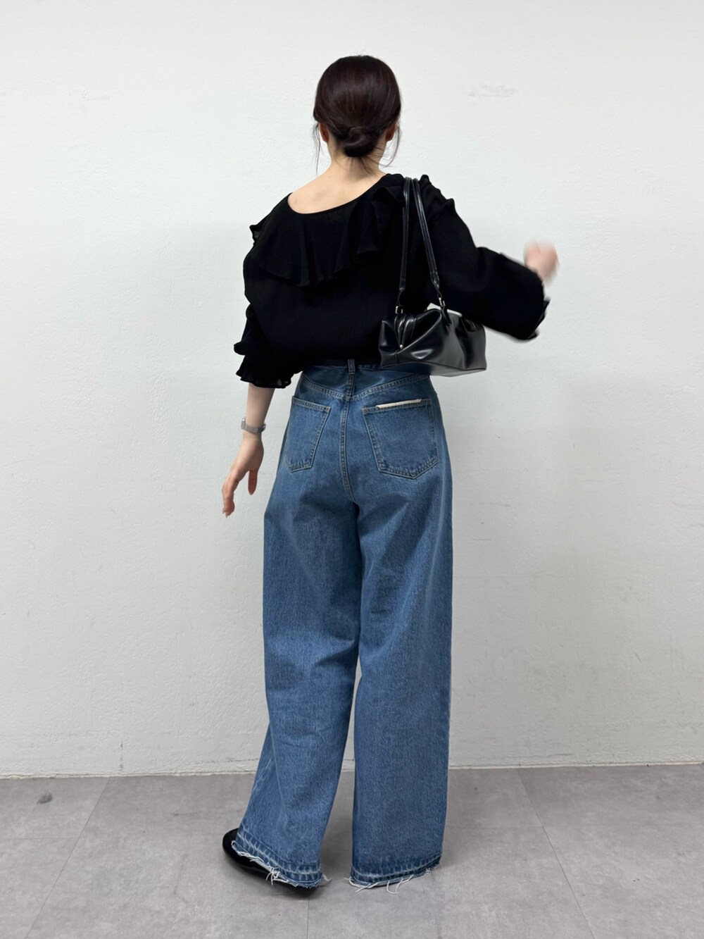 ブラック系のシャツ/ブラウス、ブルー系のデニムパンツ、ブラック系のトートバッグを着用したレディースの春コーディネートの3枚目の写真