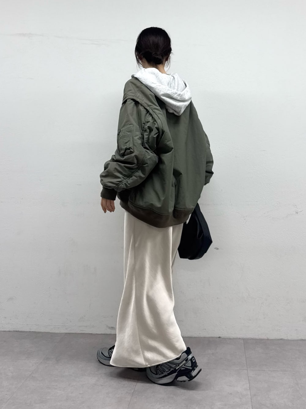 グリーン系のMA-1、グレー系のパーカー、ホワイト系のスカートを着用したレディースの夏コーディネートの2枚目の写真