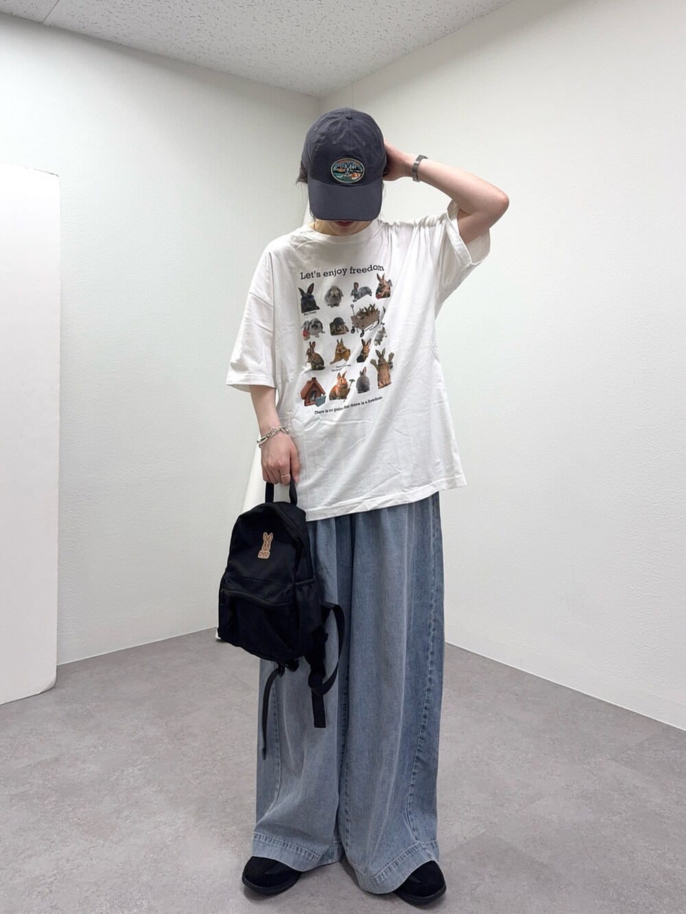 ホワイト系のTシャツ/カットソー、ブルー系のデニムパンツ、グレー系のキャップを着用したレディースの春コーディネートの3枚目の写真