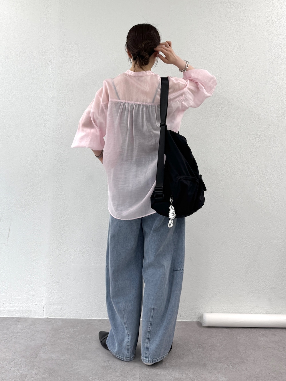 ピンク系のシャツ/ブラウス、ブルー系のデニムパンツ、ブラック系のパンプスを着用したレディースの春コーディネートの3枚目の写真