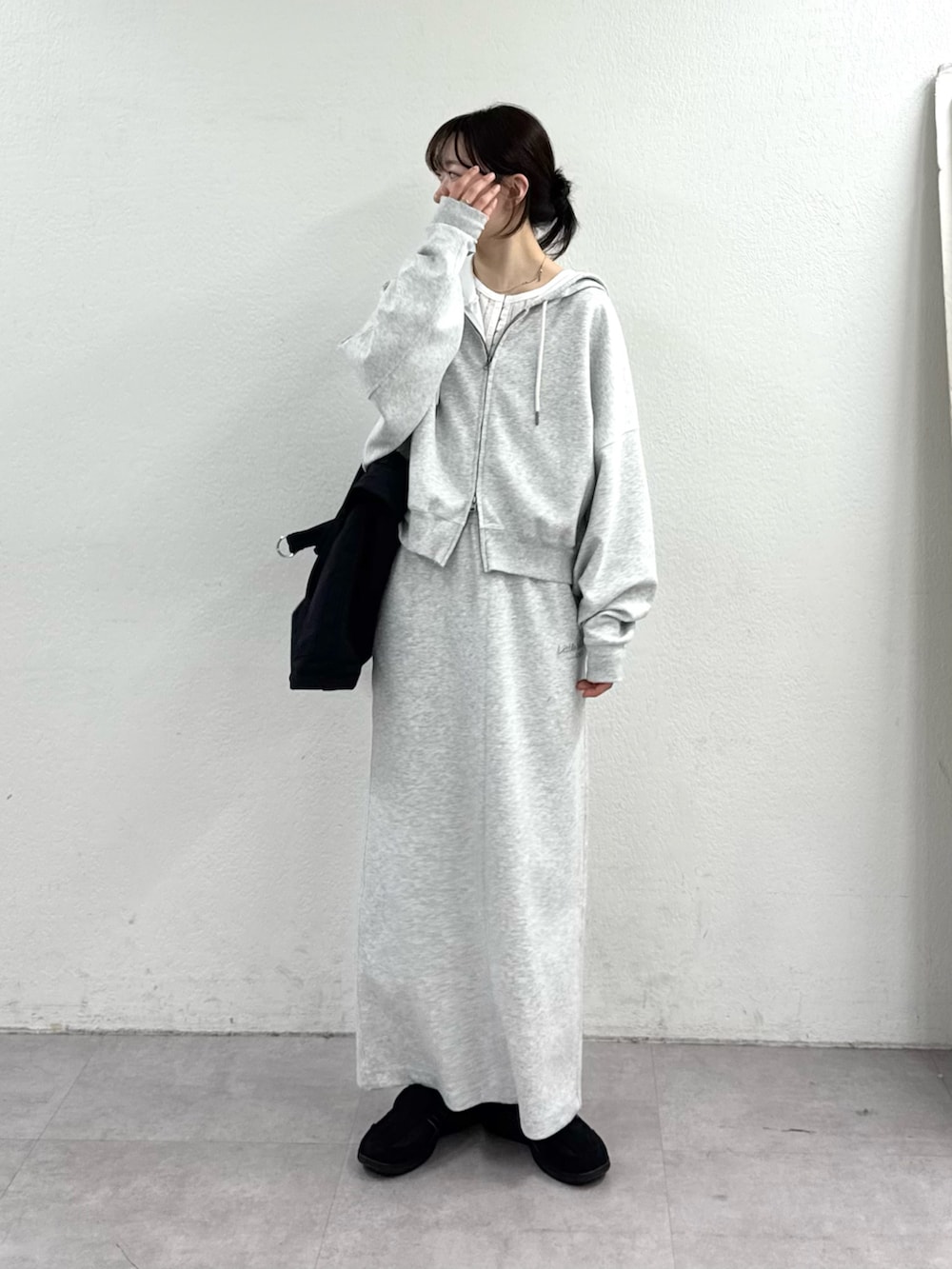 グレー系のパーカー、ブラック系のショルダーバッグを着用したレディースの春コーディネートの3枚目の写真