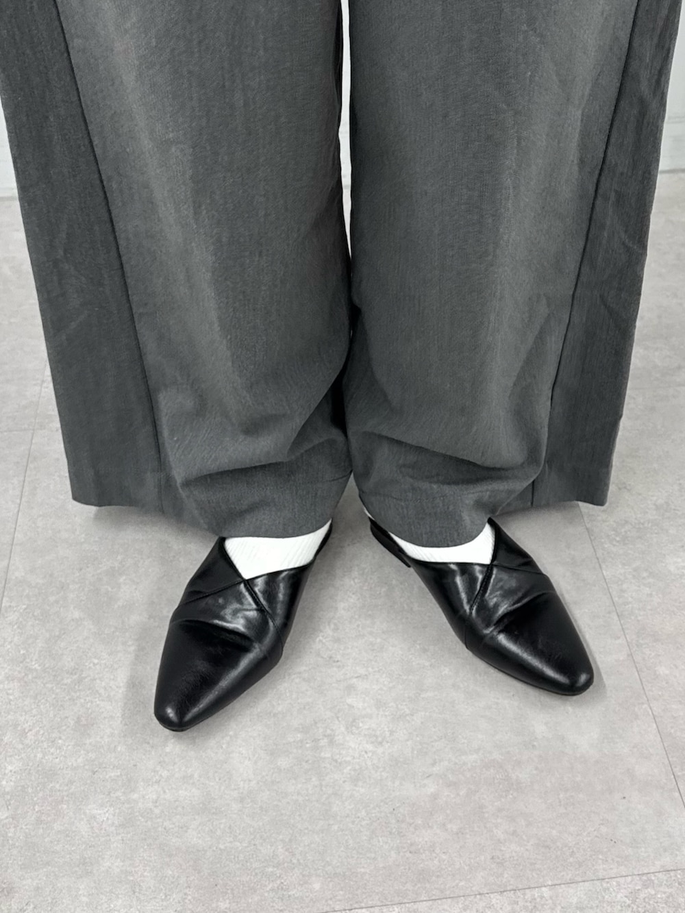 ブラック系のTシャツ/カットソー、ブラック系のショルダーバッグ、グレー系のデニムパンツを着用したレディースの春コーディネートの5枚目の写真